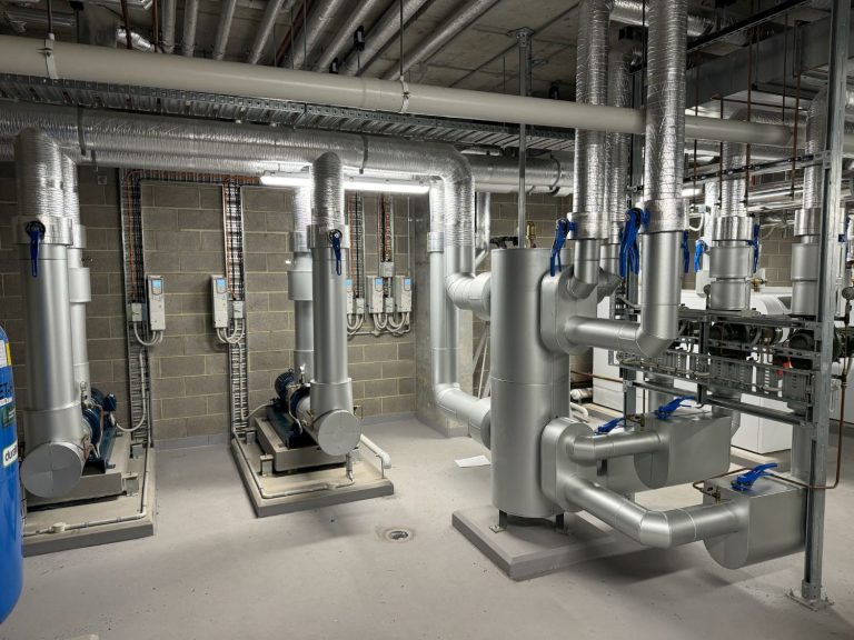 Insulated and clad pumps and pipework in a commercial plant room